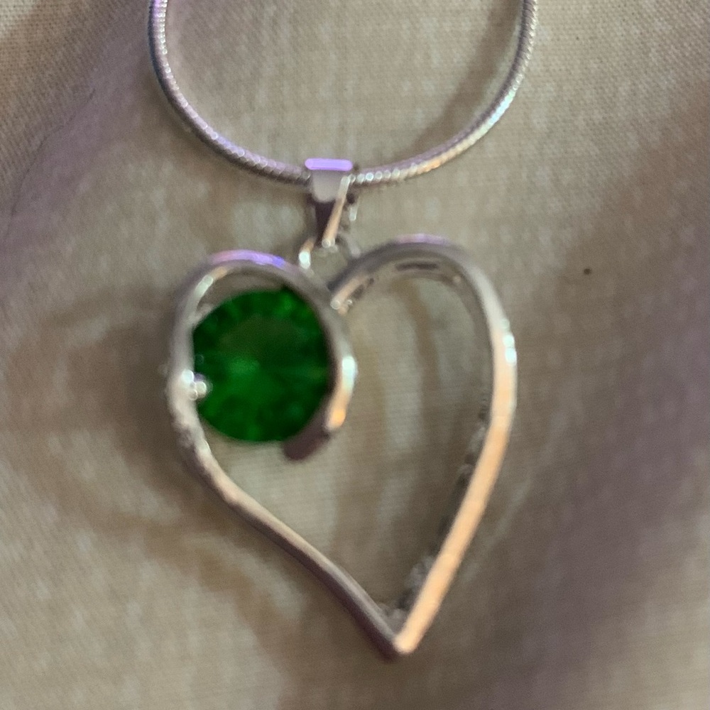 Emerald heart silver charm on silver 18” chain.